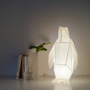 Small Penguin in Cotton White  with books and a plant in the background